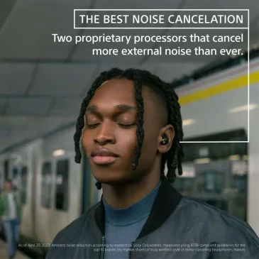 Young man with dreadlocks closes his eyes on a subway while wearing Sony noise-cancelling earbuds.
