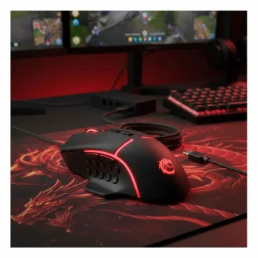 Red-lit gaming mouse on a desk with monitors and keyboard in the background.