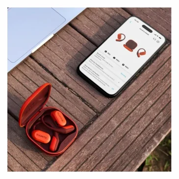 Suunto Spark Coral Orange wireless earbuds with the companion app open on a phone